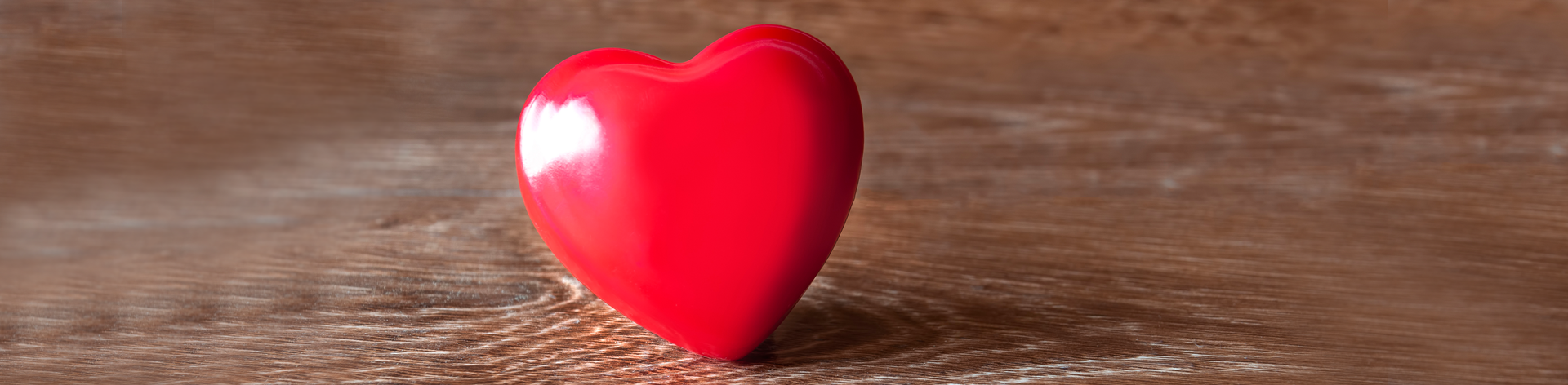 Red heart on a wooden table.